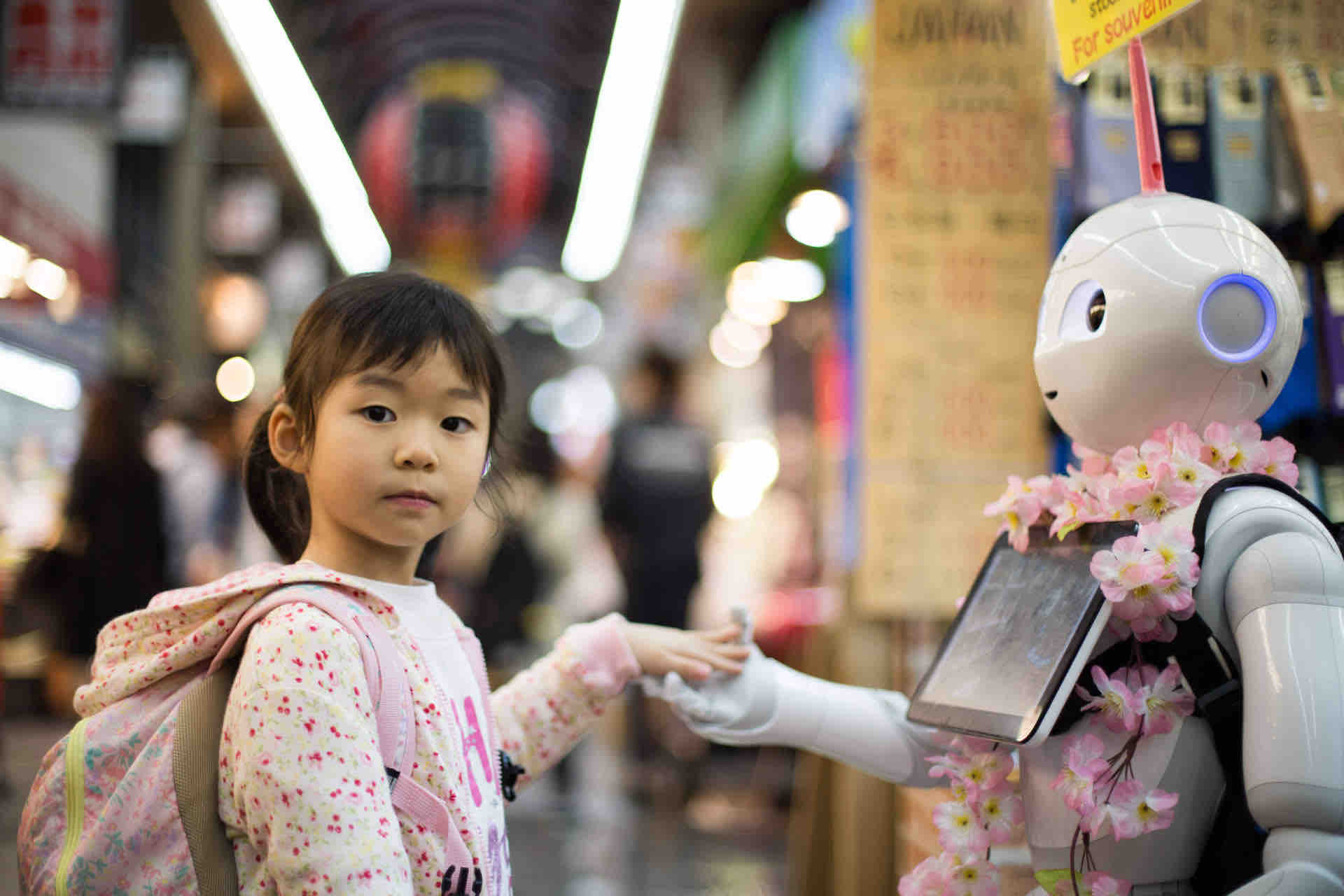 Girl shaking the hand of a robot