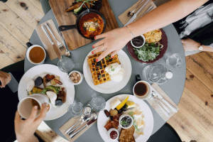 Thumbnail of food set on the table with people around, reaching for the food